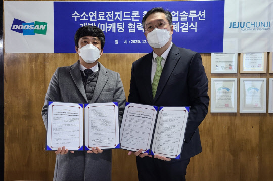 이두순 DMI 대표(오른쪽)와 송진영 제주천지 대표가 '수소연료전지드론을 활용한 농업 솔루션 개발' 업무협약식을 마치고 기념사진을 촬영하고 있다. <두산그룹 제공>